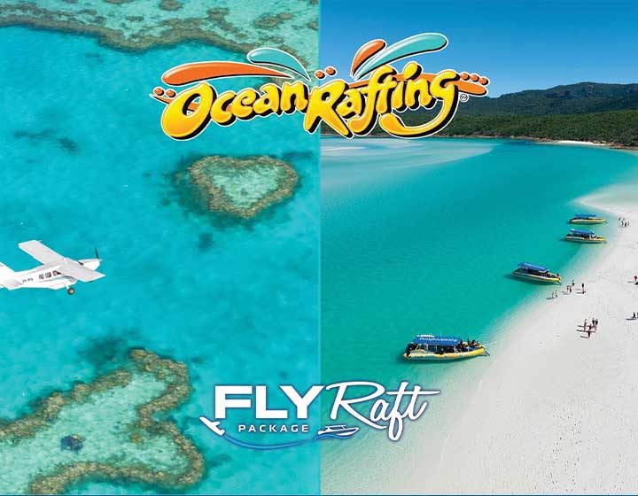 Ocean Rafting Fly Raft package: a scenic plane over Heart Reef beside Ocean Rafting boats on the white sand at Whitehaven Beach
