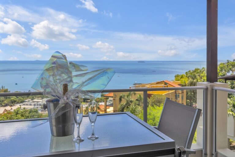 Champagne on a balcony table with the Coral Sea behind, 1 bedroom apartment at Whitsunday Reflections