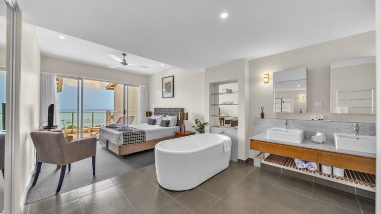 Main bedroom with king bed and freestanding bath opening to a Coral Sea view, 1 bedroom apartment at Whitsunday Reflections