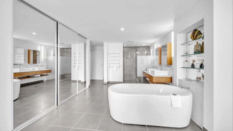 Main ensuite with freestanding bath, twin vessel basins, walk-in shower and mirrored robe doors, 2 bedroom apartment at Whitsunday Reflections, Airlie Beach