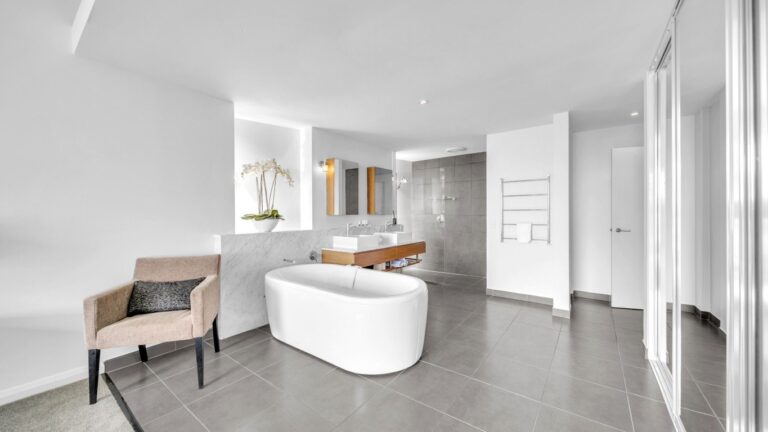 Freestanding bath in front of a marble wall with twin basins and walk-in shower behind, 2 bedroom apartment at Whitsunday Reflections, Airlie Beach