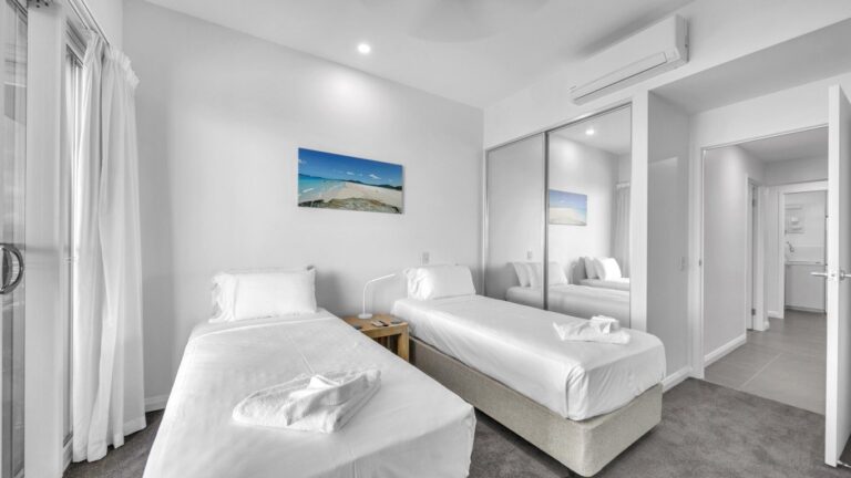Second bedroom with two single beds, mirrored robe and air conditioning, 2 bedroom apartment at Whitsunday Reflections, Airlie Beach