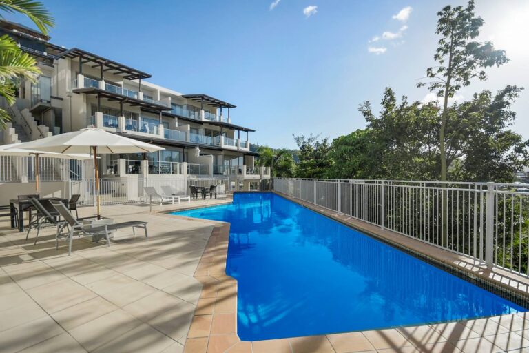 20 metre lap pool beside the terraced apartments with sun lounges, shade umbrellas and outdoor dining on the pool deck, Whitsunday Reflections, Airlie Beach
