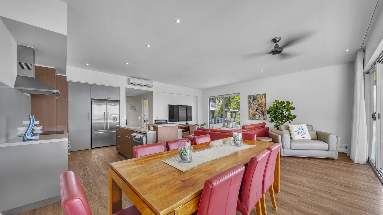Dining table, kitchen and lounge in a three bedroom apartment at Whitsunday Reflections, Airlie Beach