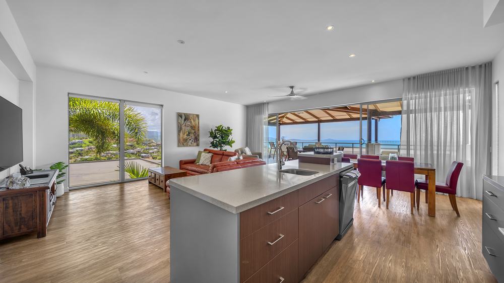 Three bedroom apartment Bosch kitchen, lounge and dining with view through to the deck at Whitsunday Reflections, Airlie Beach