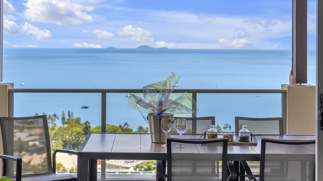 Balcony table with wine overlooking Pioneer Bay and the Whitsunday Islands from Whitsunday Reflections, Airlie Beach