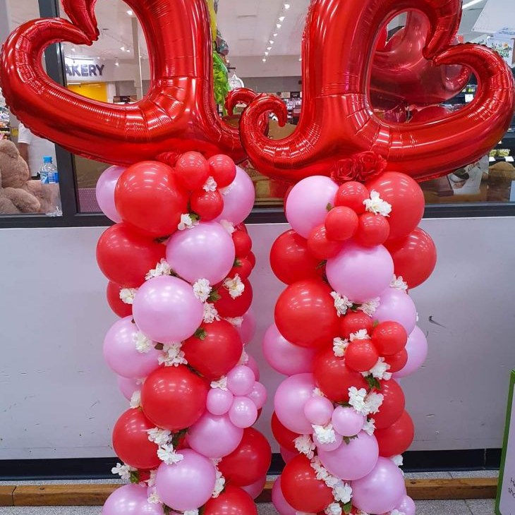 Pair of red and pink balloon columns topped with large red heart foil balloons, balloon decorations delivered to Whitsunday Reflections, Airlie Beach