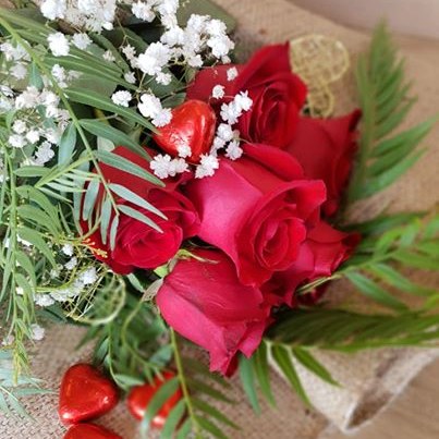 Red roses with baby's breath and chocolate hearts wrapped in hessian, flowers delivered to your apartment at Whitsunday Reflections, Airlie Beach