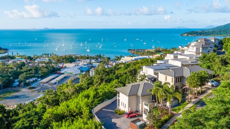 Aerial view from the Horizons Way hillside over Airlie Beach and yachts moored in Pioneer Bay to the Coral Sea and Whitsunday Islands, near Whitsunday Reflections apartments, Airlie Beach